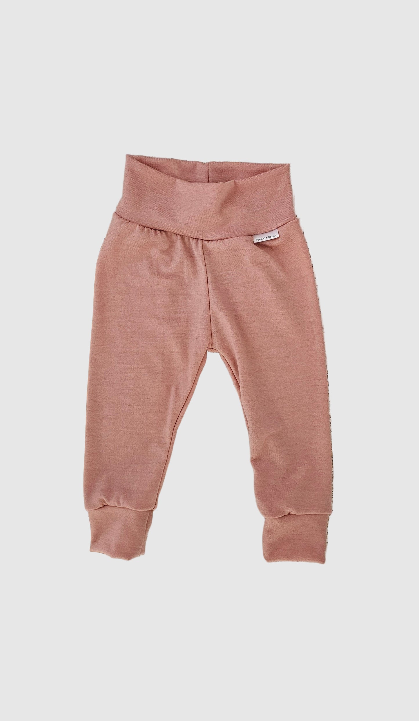 Pink baby pants on a wooden surface