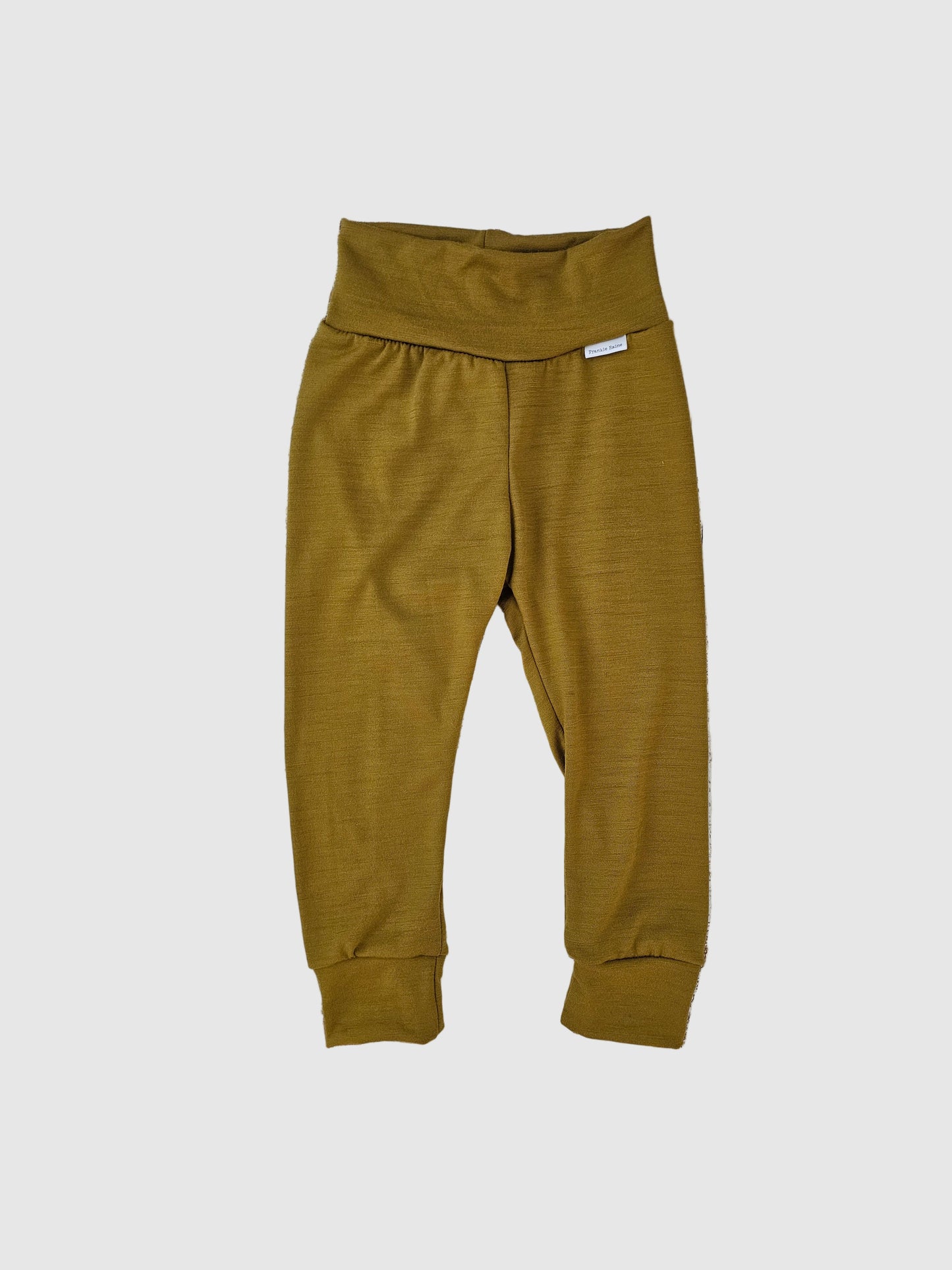 Pair of mustard yellow pants on a wooden surface