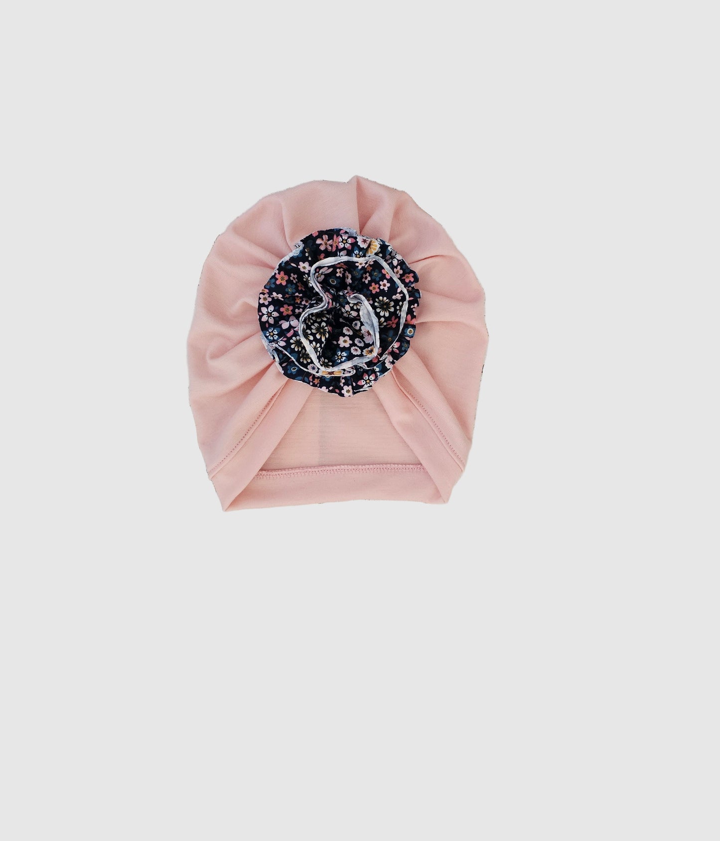 Pink headband with floral design on a wooden surface