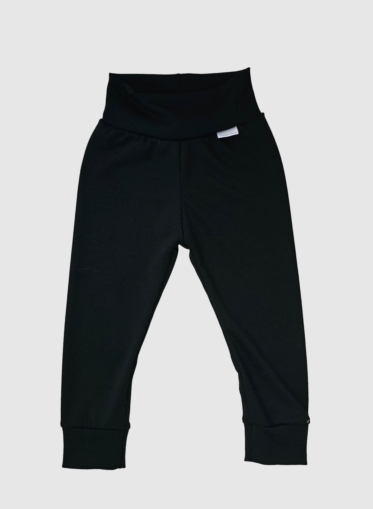 Black pants on a light wooden surface