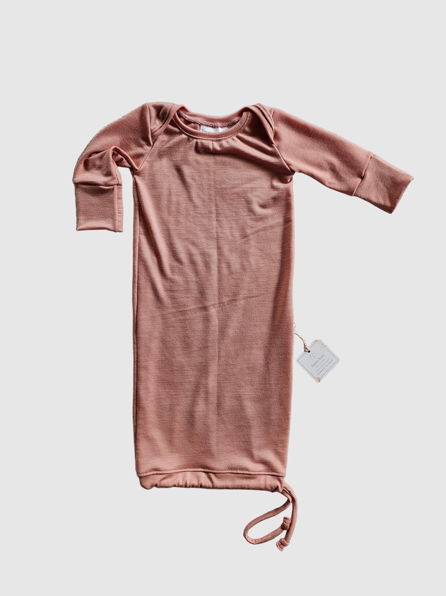 Pink long-sleeve top on a textured gray surface