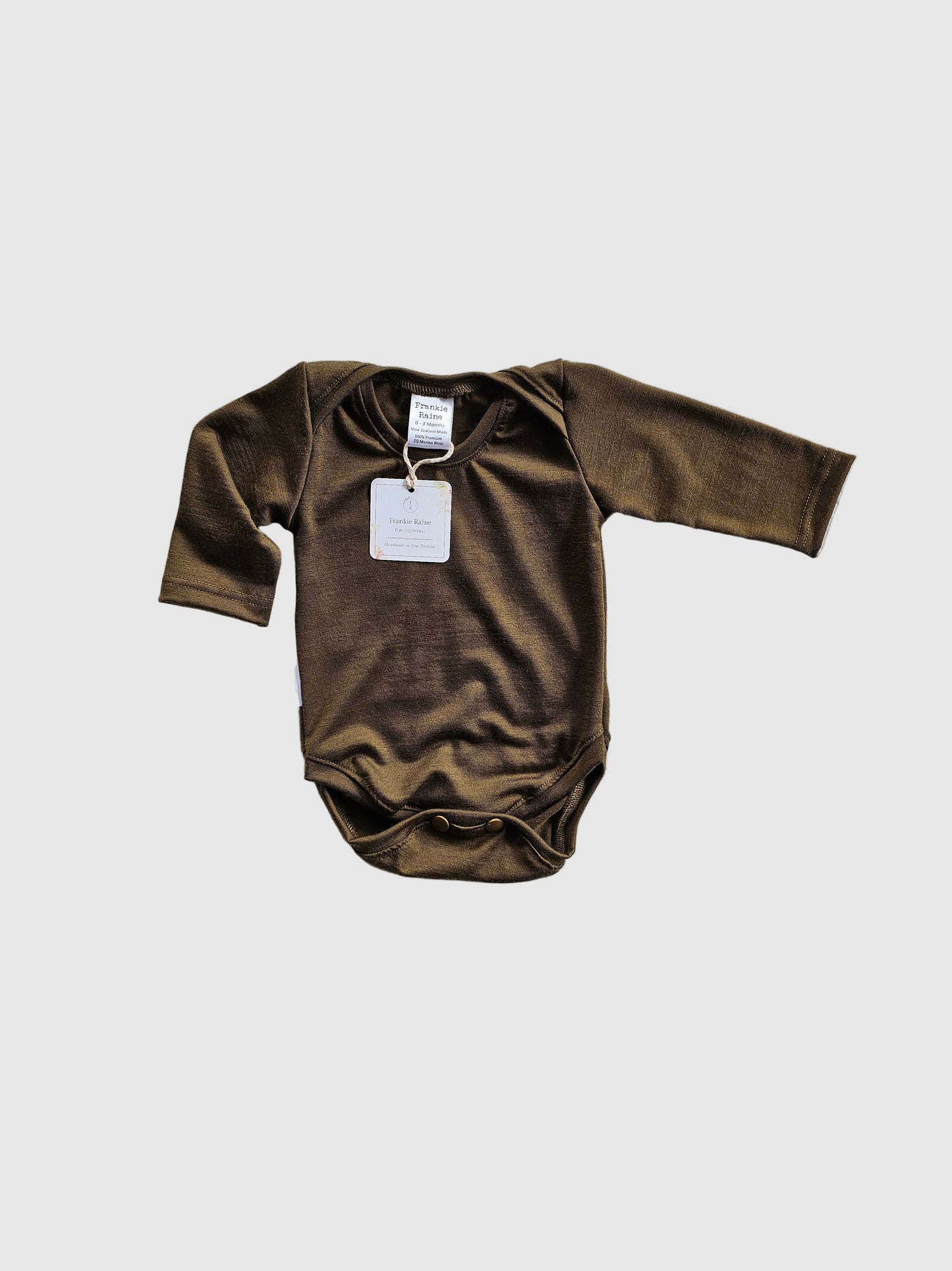 Brown baby onesie with a tag on a gray textured background