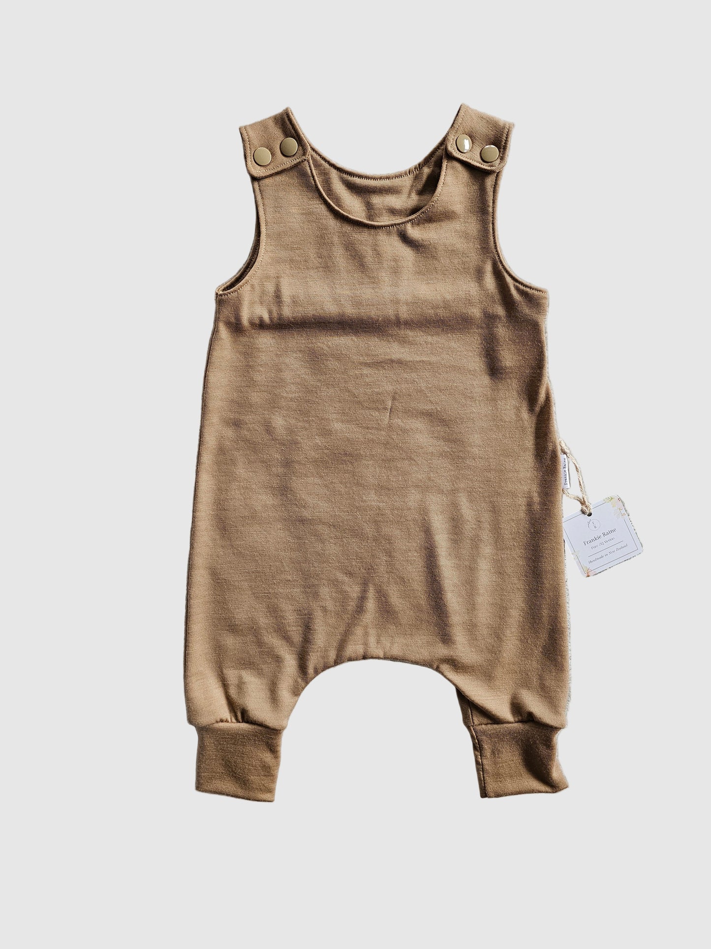 Brown baby romper on a textured gray surface