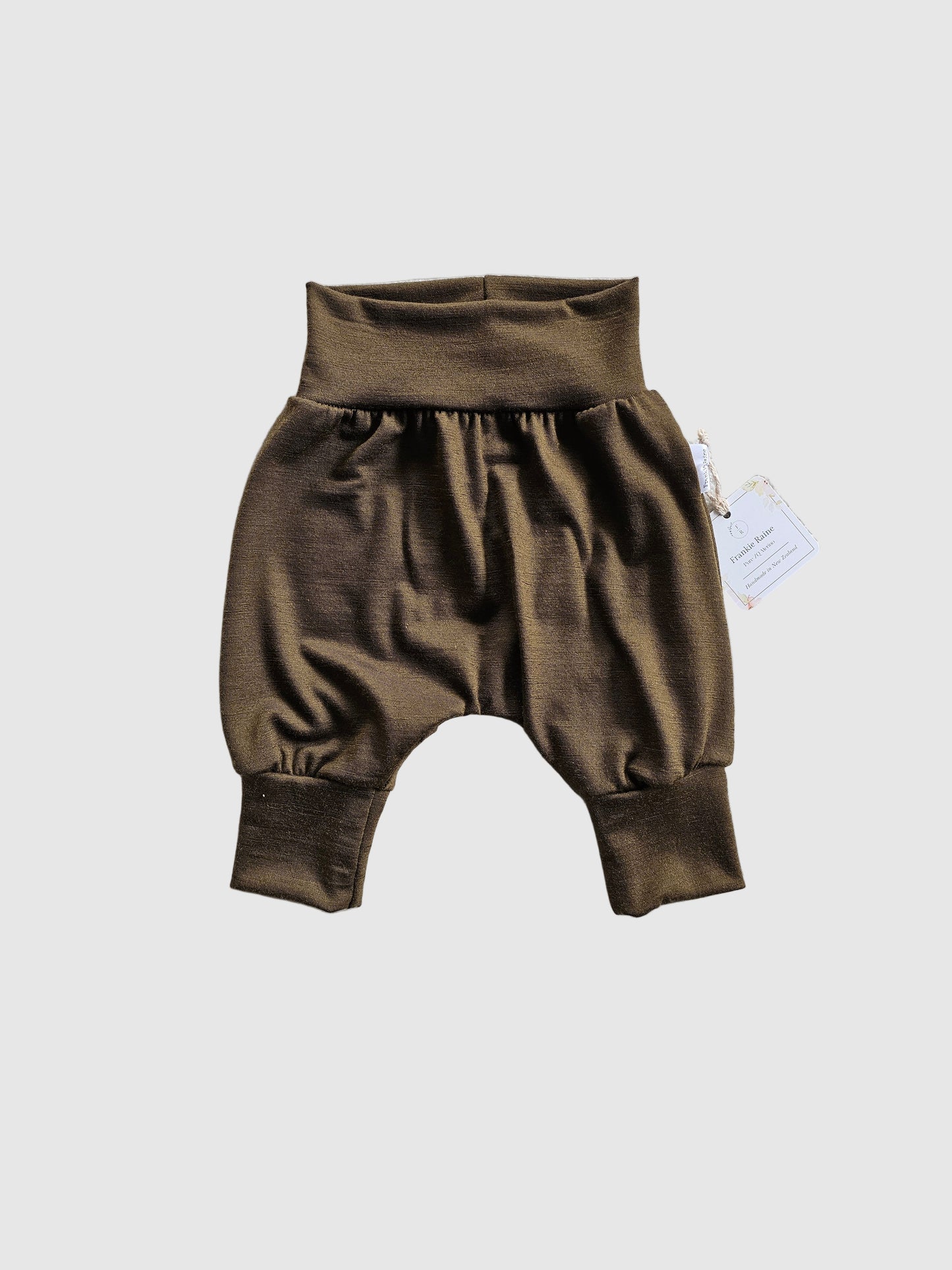 Brown baby romper on a textured gray surface