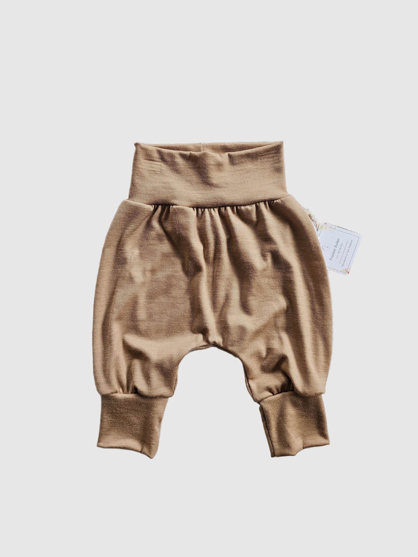 Brown baby romper on a textured gray surface