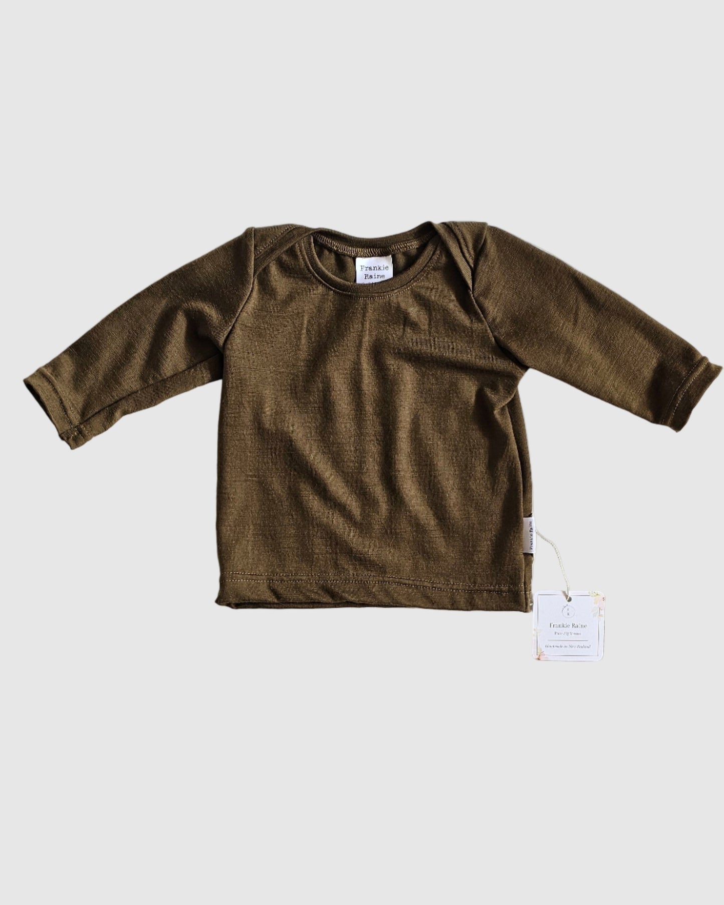 Brown long-sleeve shirt on a white textured surface