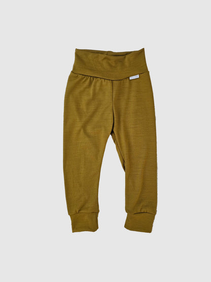Pair of mustard yellow pants on a wooden surface