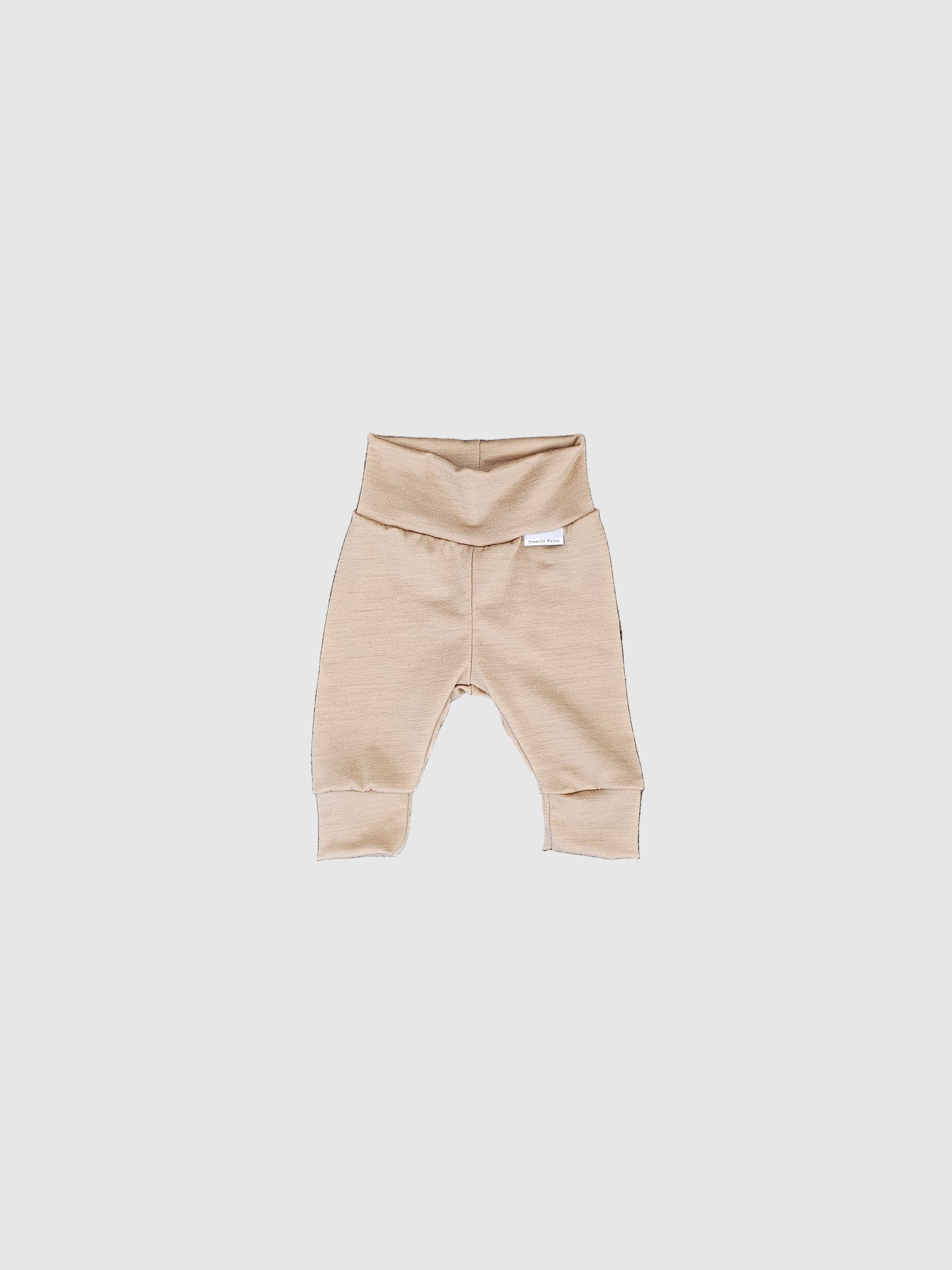 Beige baby romper on a textured gray surface