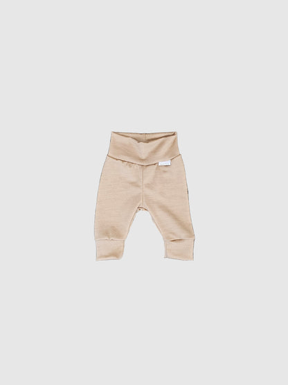Beige baby romper on a textured gray surface