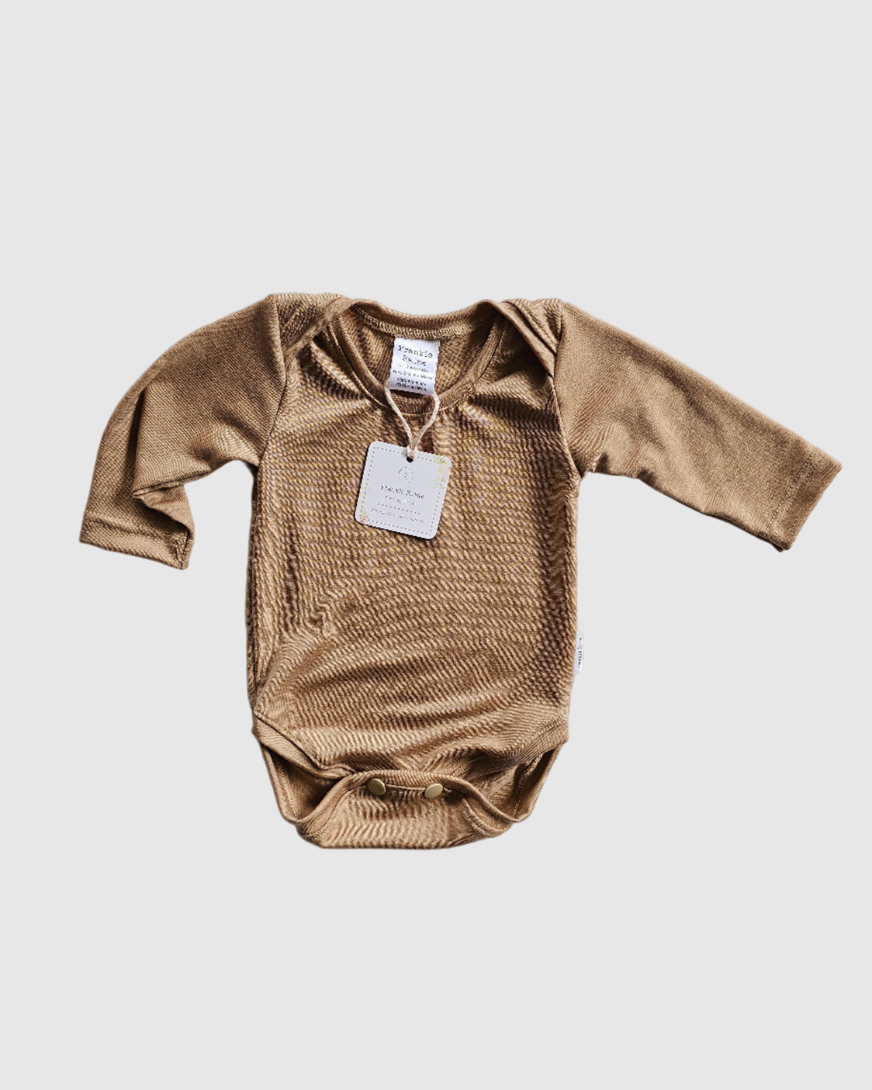 Brown long-sleeve shirt with a tag on a light gray textured surface