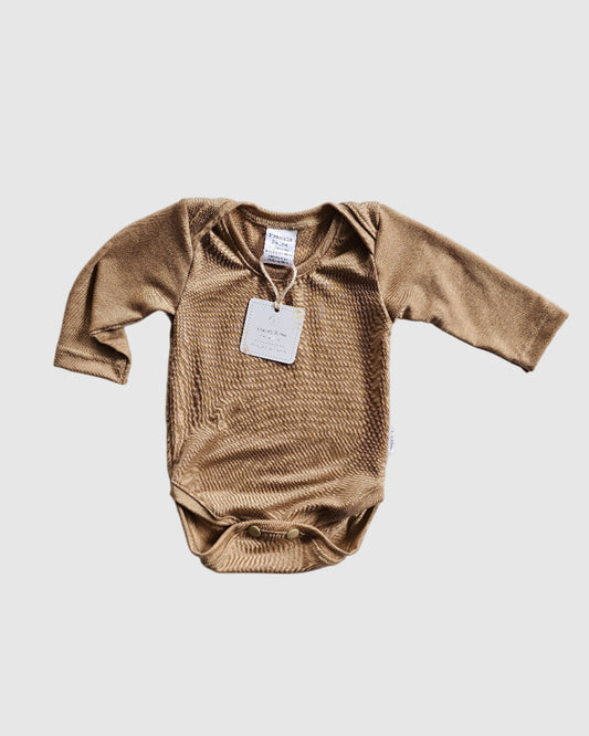 Brown long-sleeve shirt with a tag on a light gray textured surface