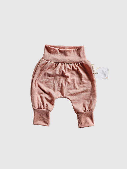 Pink baby romper on a textured light gray surface
