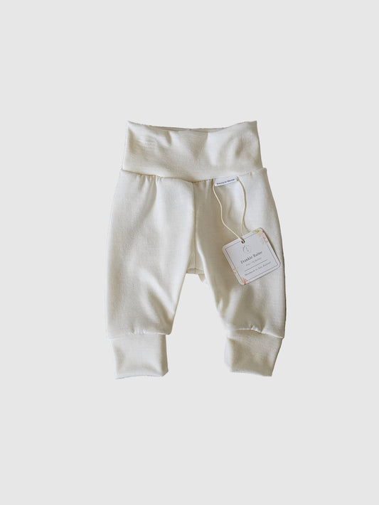 White pants with a tag on a textured gray surface
