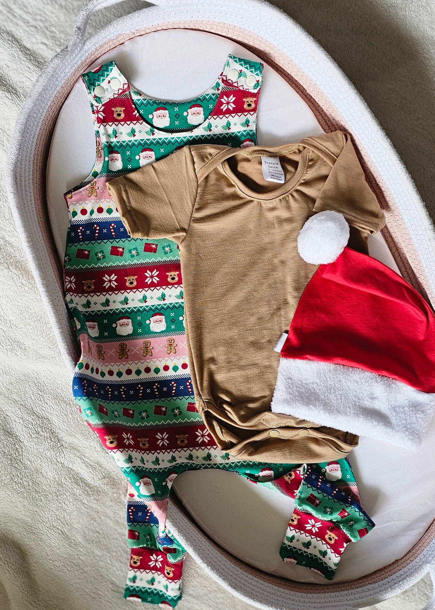 Baby outfit with brown shirt, red hat, and patterned pants on a white tray.