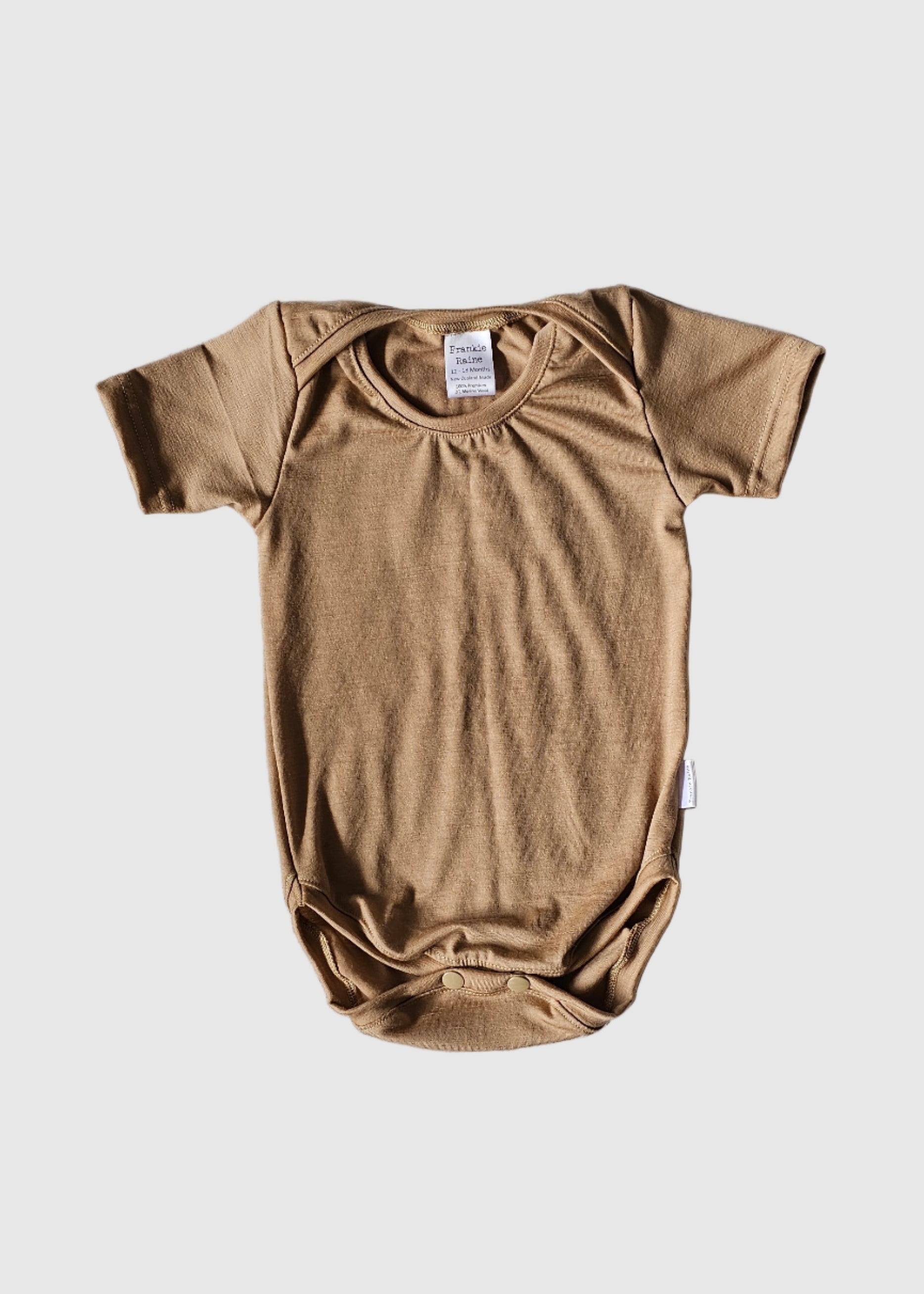 Brown baby onesie on a gray blanket