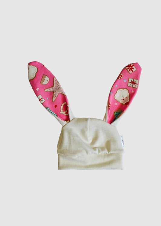 Pair of pink slippers with white hearts on a light gray surface