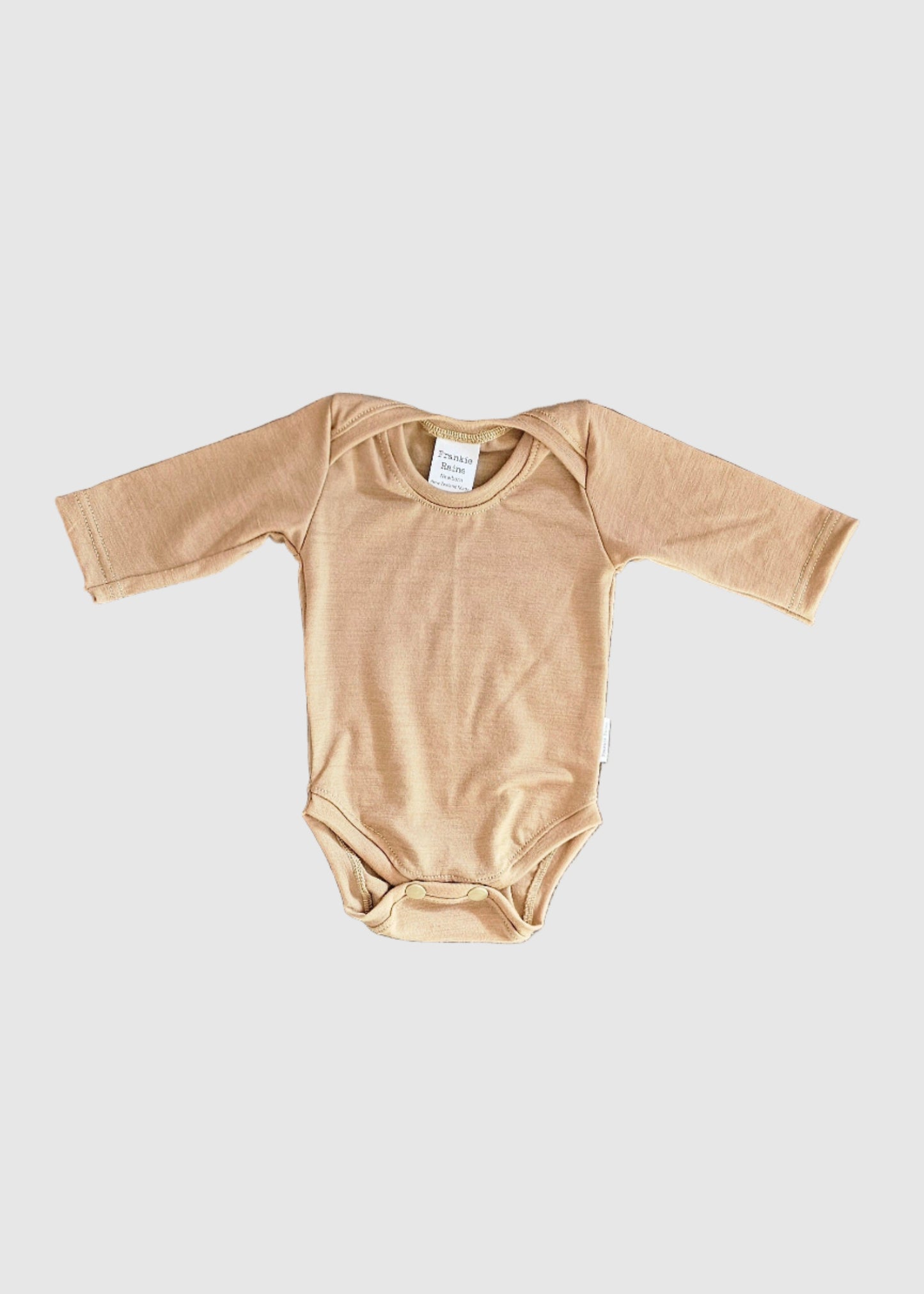 Beige baby onesie on a carpeted floor