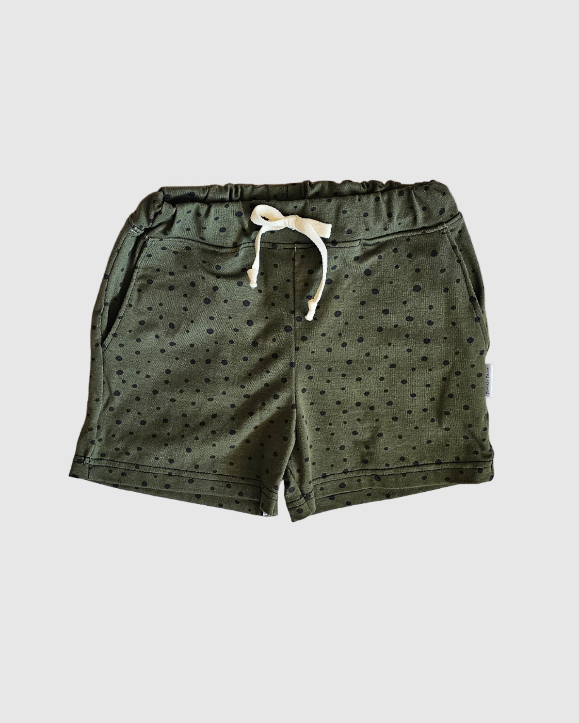 Green shorts with a white drawstring on a checkered fabric background