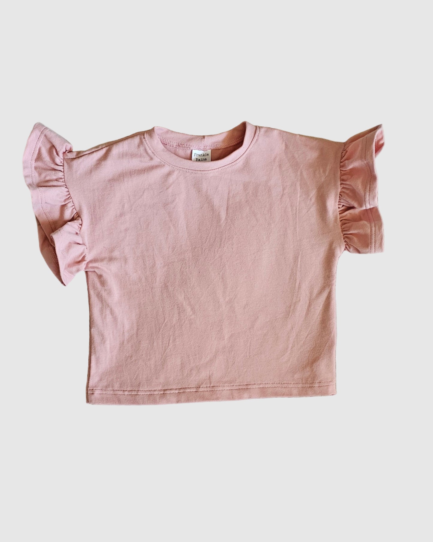 Pink blouse with ruffled sleeves on a light gray background