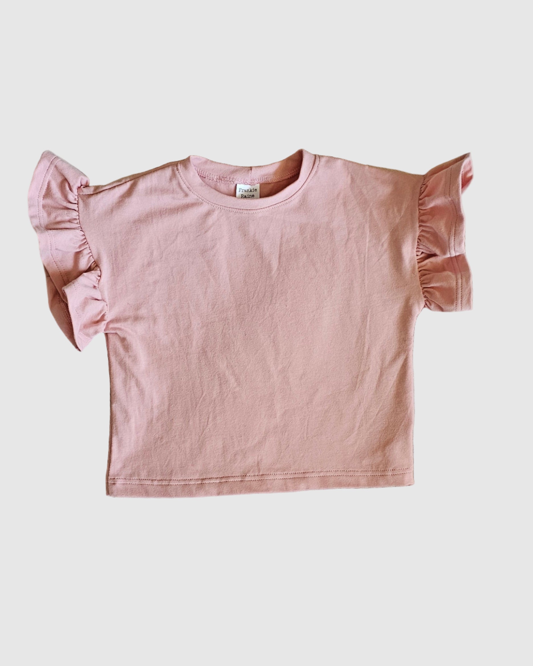 Pink blouse with ruffled sleeves on a light gray background
